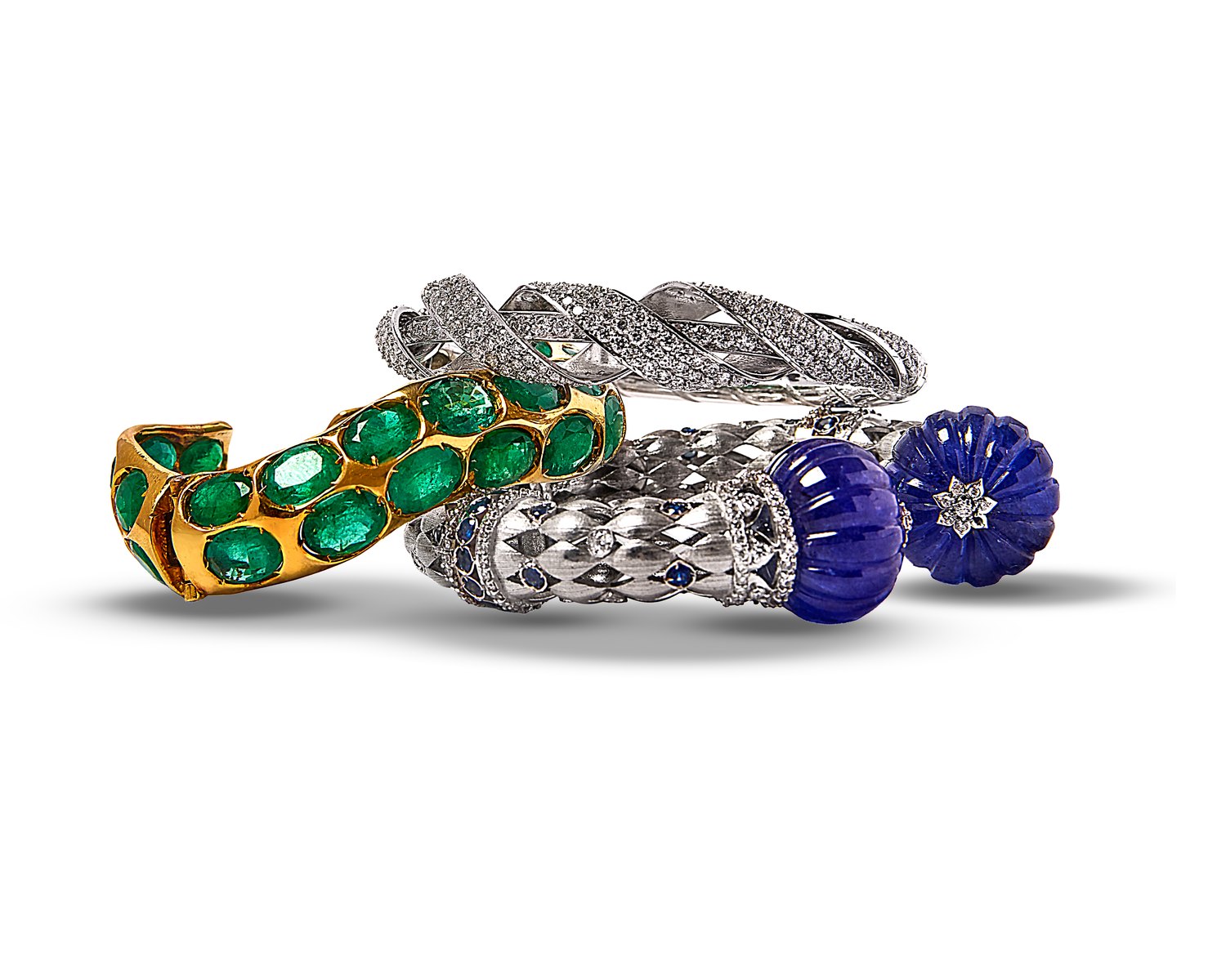 Stack of bangles: emerald gold cuff, diamond twist bangle and tanzanite melon bangle