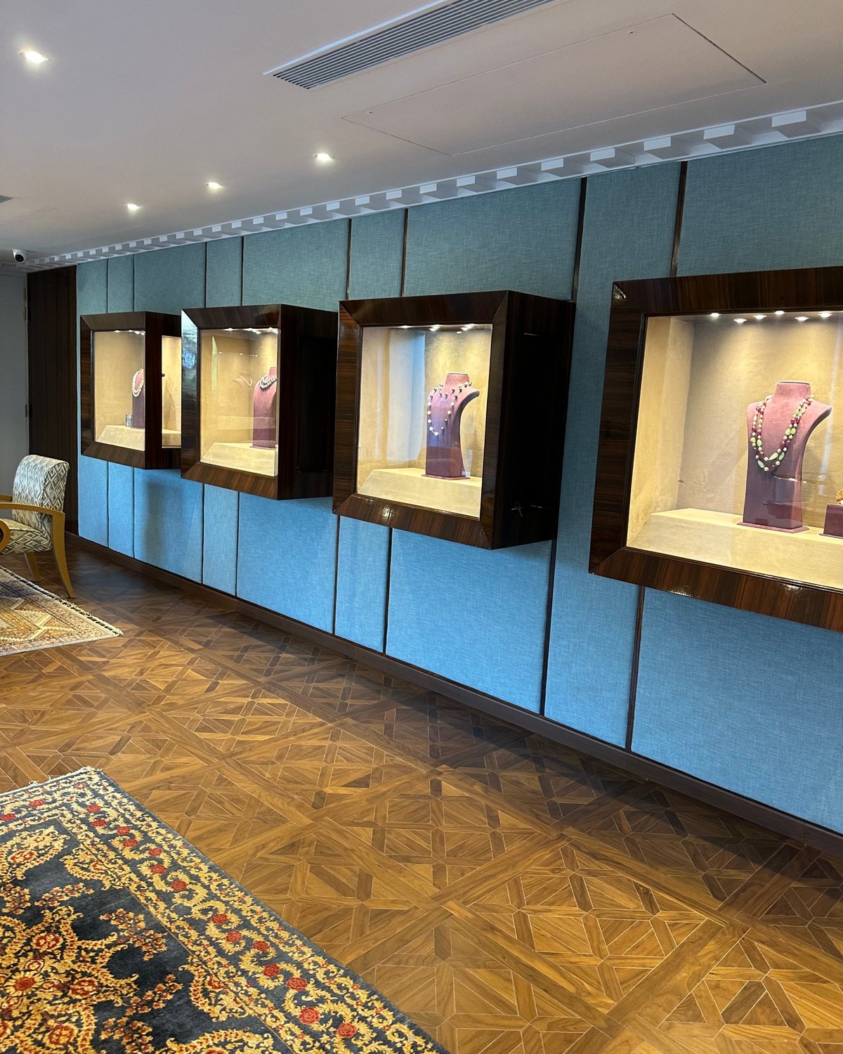 Wall of lit showcases with necklaces on display