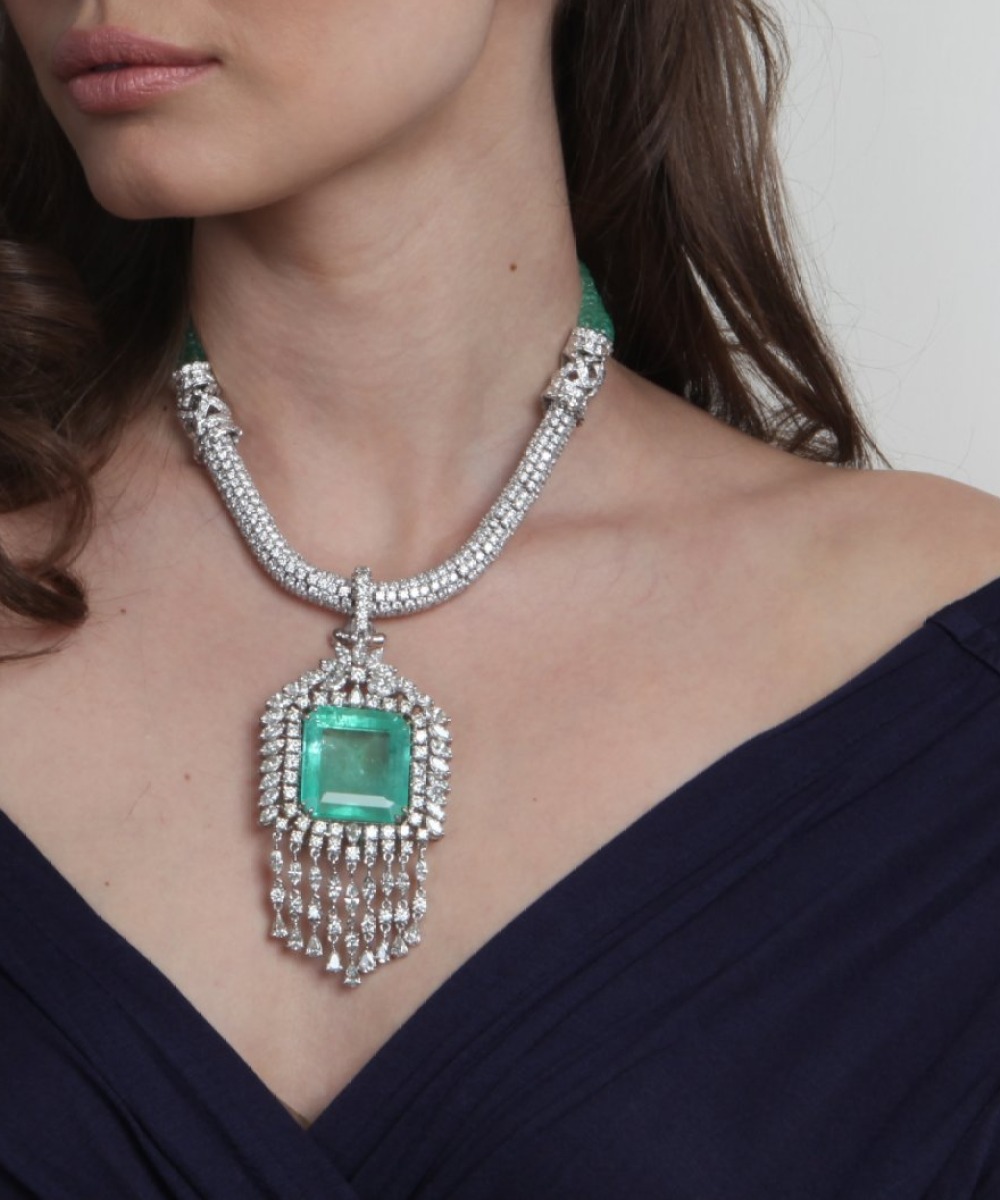 Emerald and diamond pendant necklace on an emerald bead strand, worn